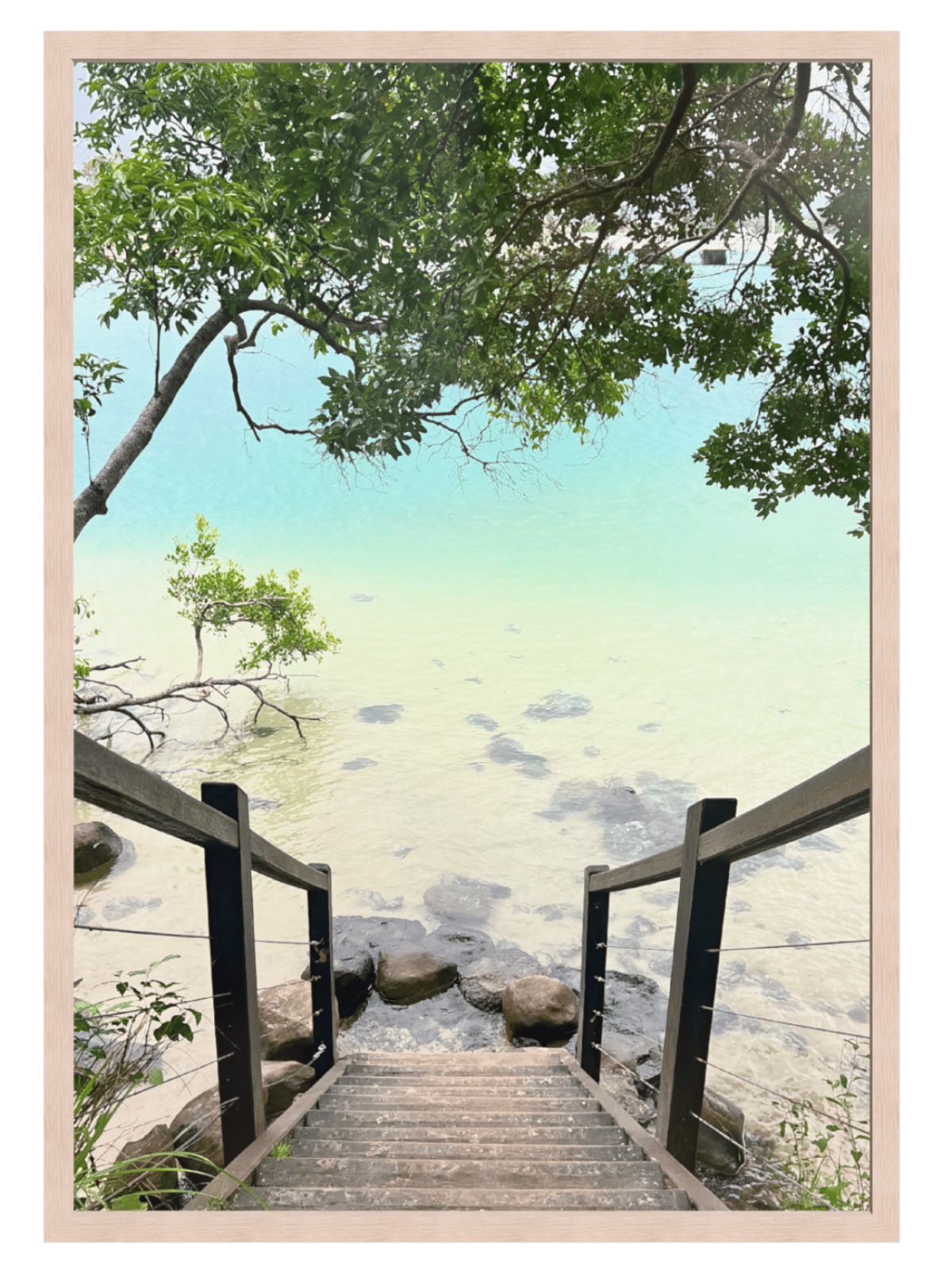 Wooden staircase leading to a body of water with trees and rocks in the background.