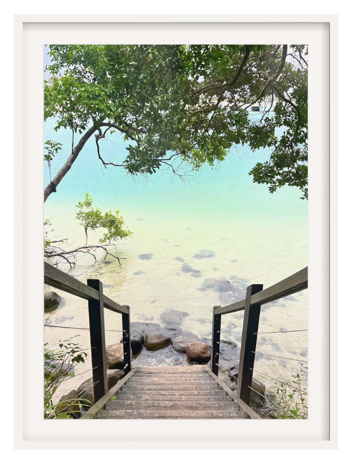 Wooden staircase leading to a beach with trees and water in the background