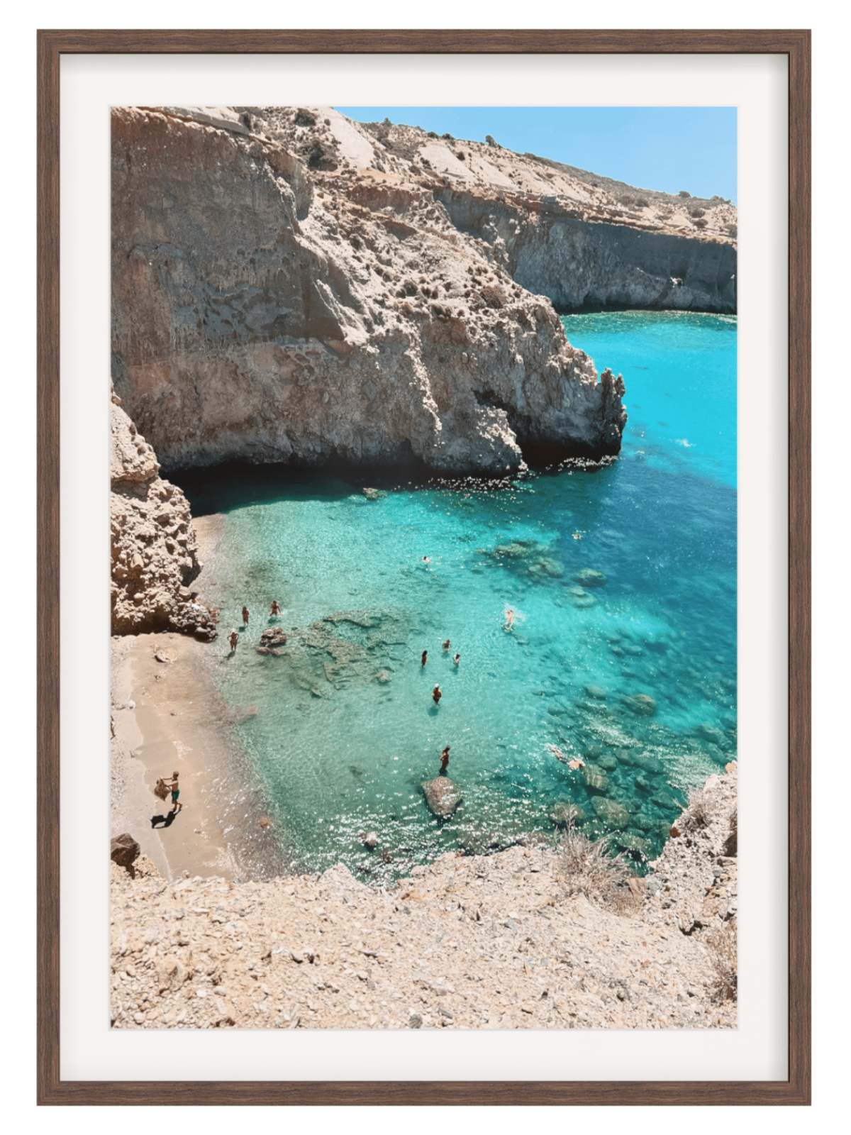 Framed photograph of a rocky cove with clear blue water and people swimming.