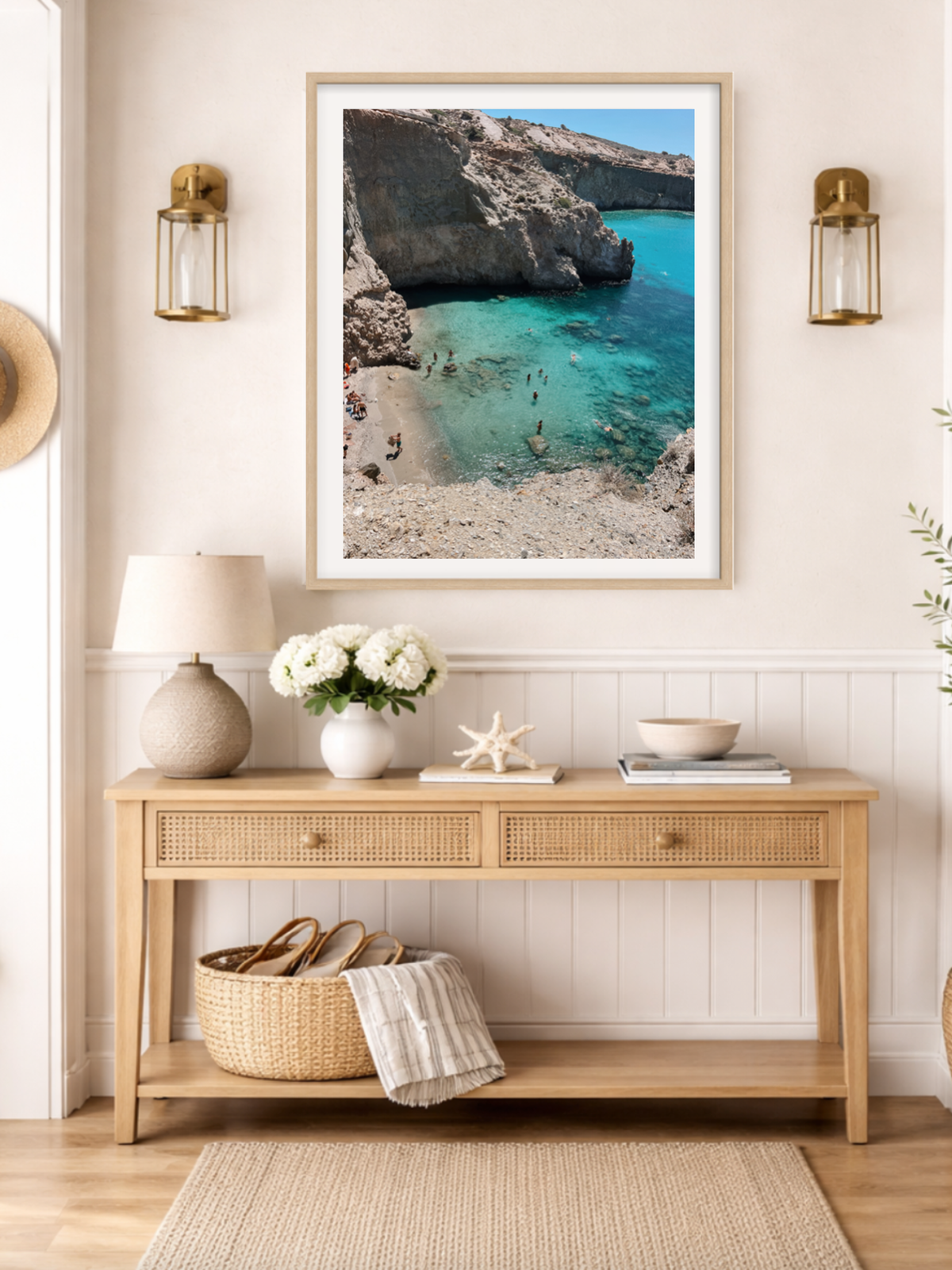 Framed beach scene above a wooden console table with decorative items.