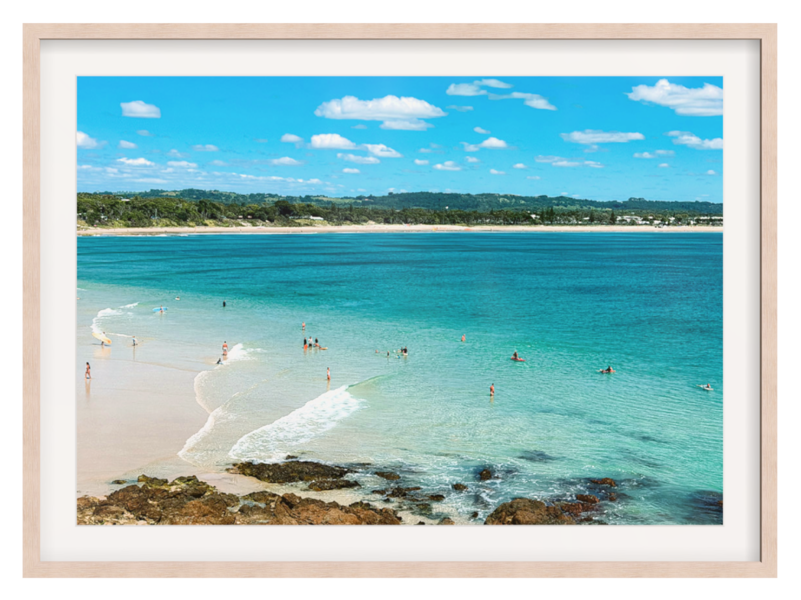 Framed artwork of a beach scene with clear blue water and white sand.