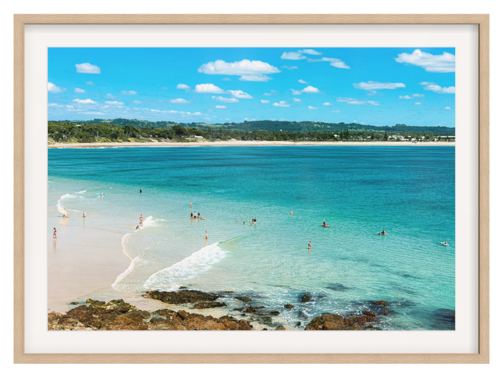 Framed photograph of a beach with clear blue water and a white frame.
