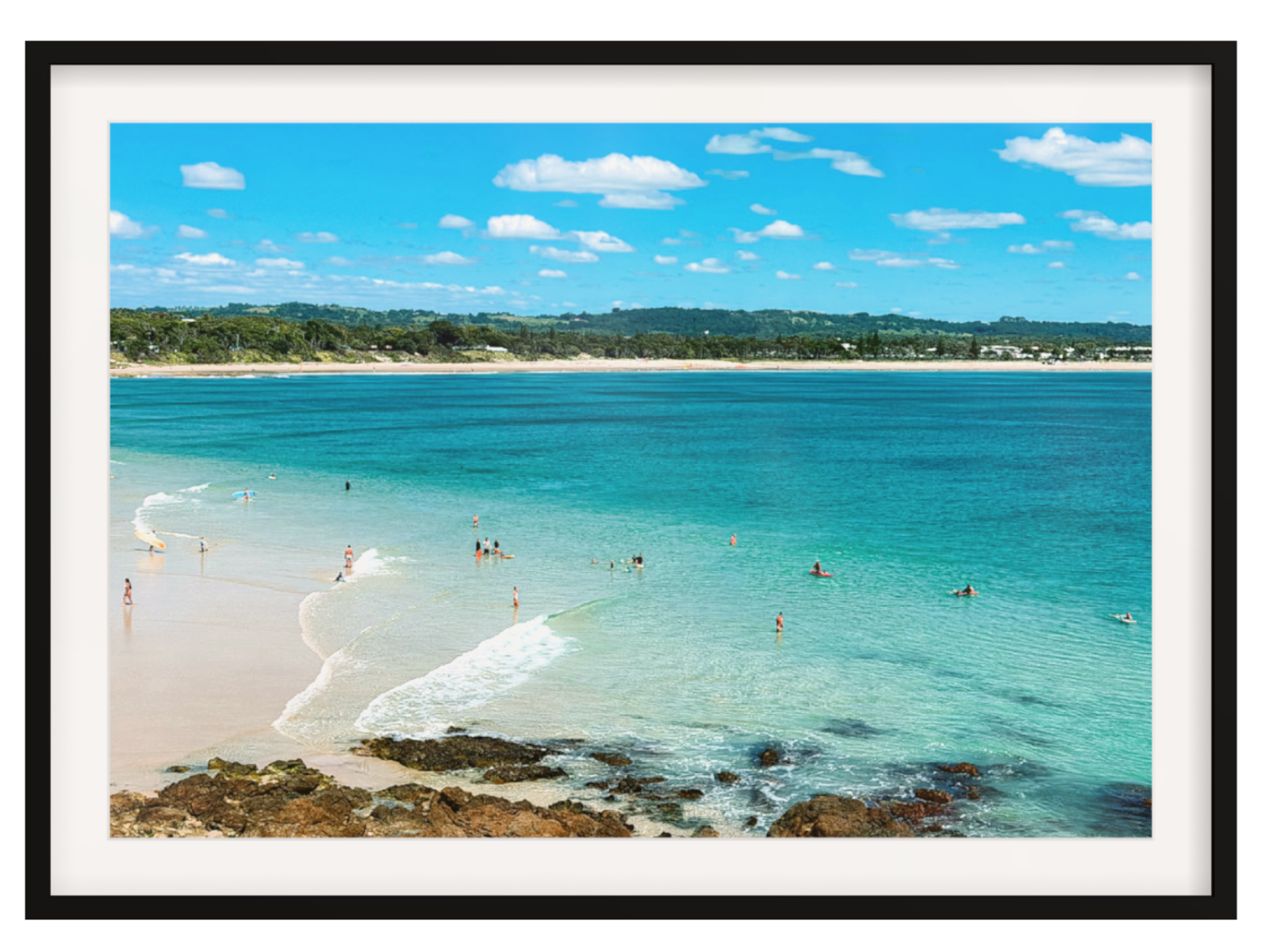 Beach scene with clear blue water and white sand, framed in black.