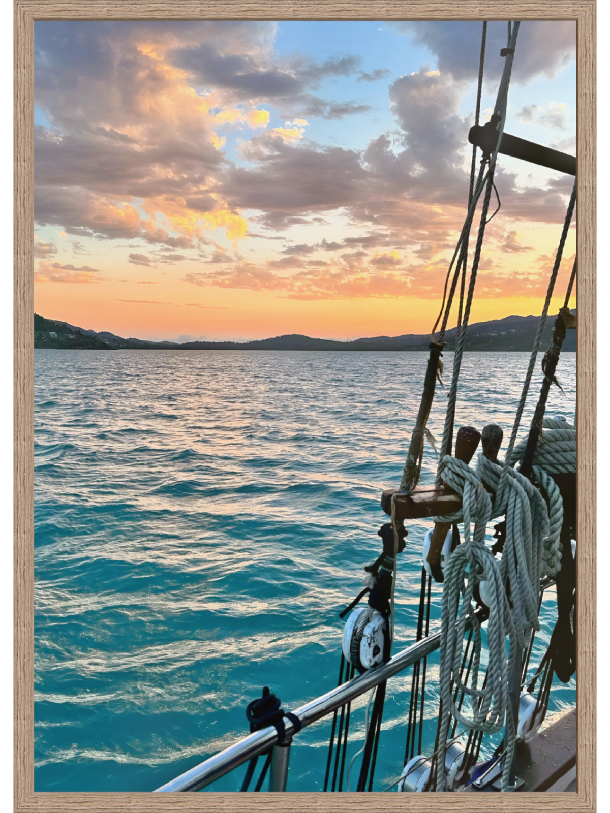 Sailing boat on the ocean with a sunset sky