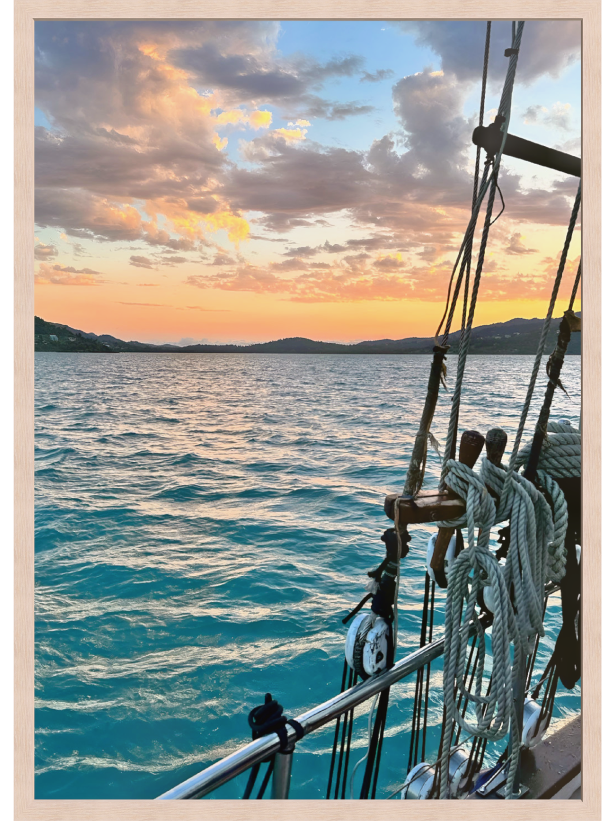 Sailing boat on the ocean with a sunset sky