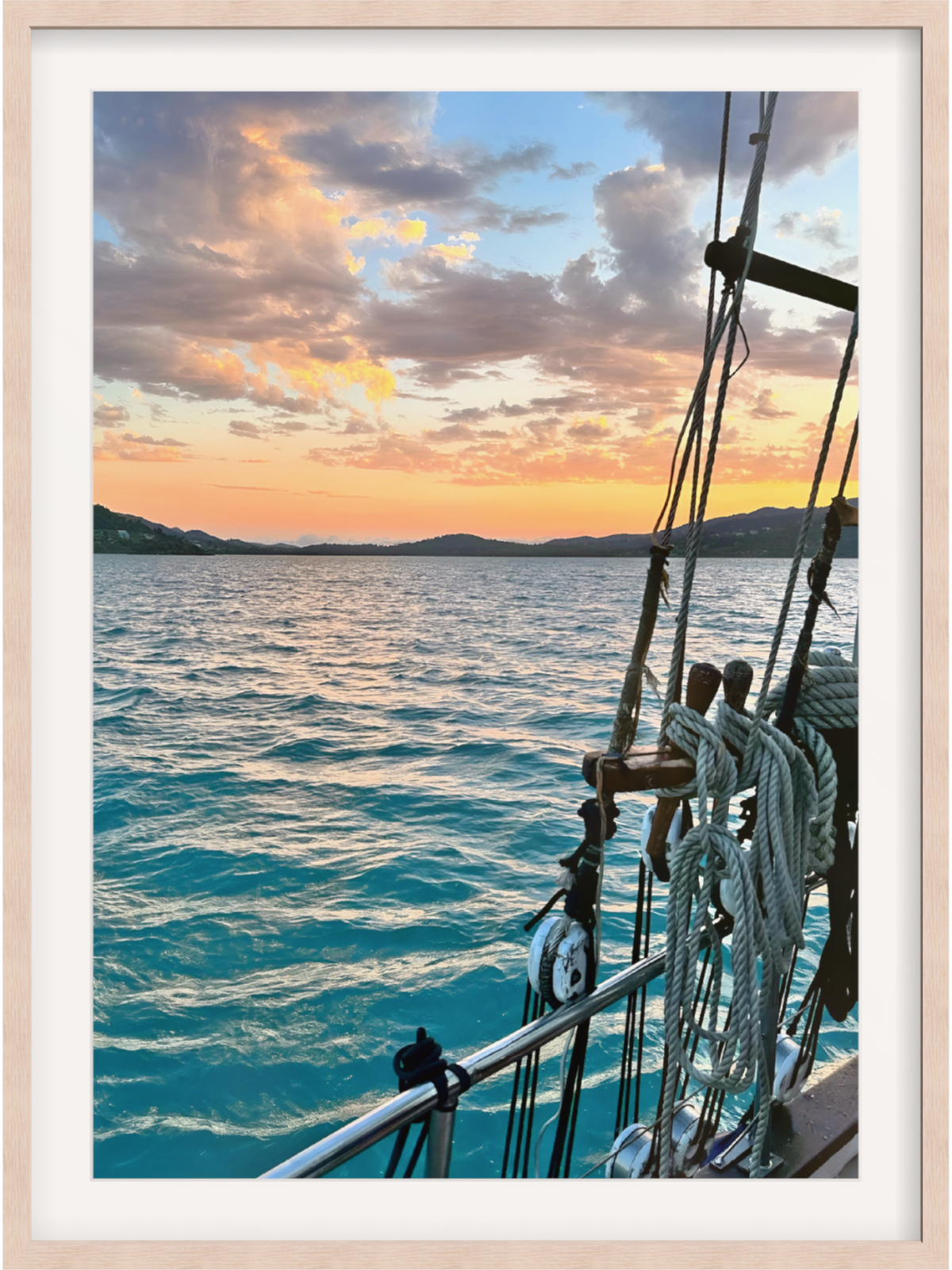 Framed photograph of a sunset over the ocean from a boat's perspective.