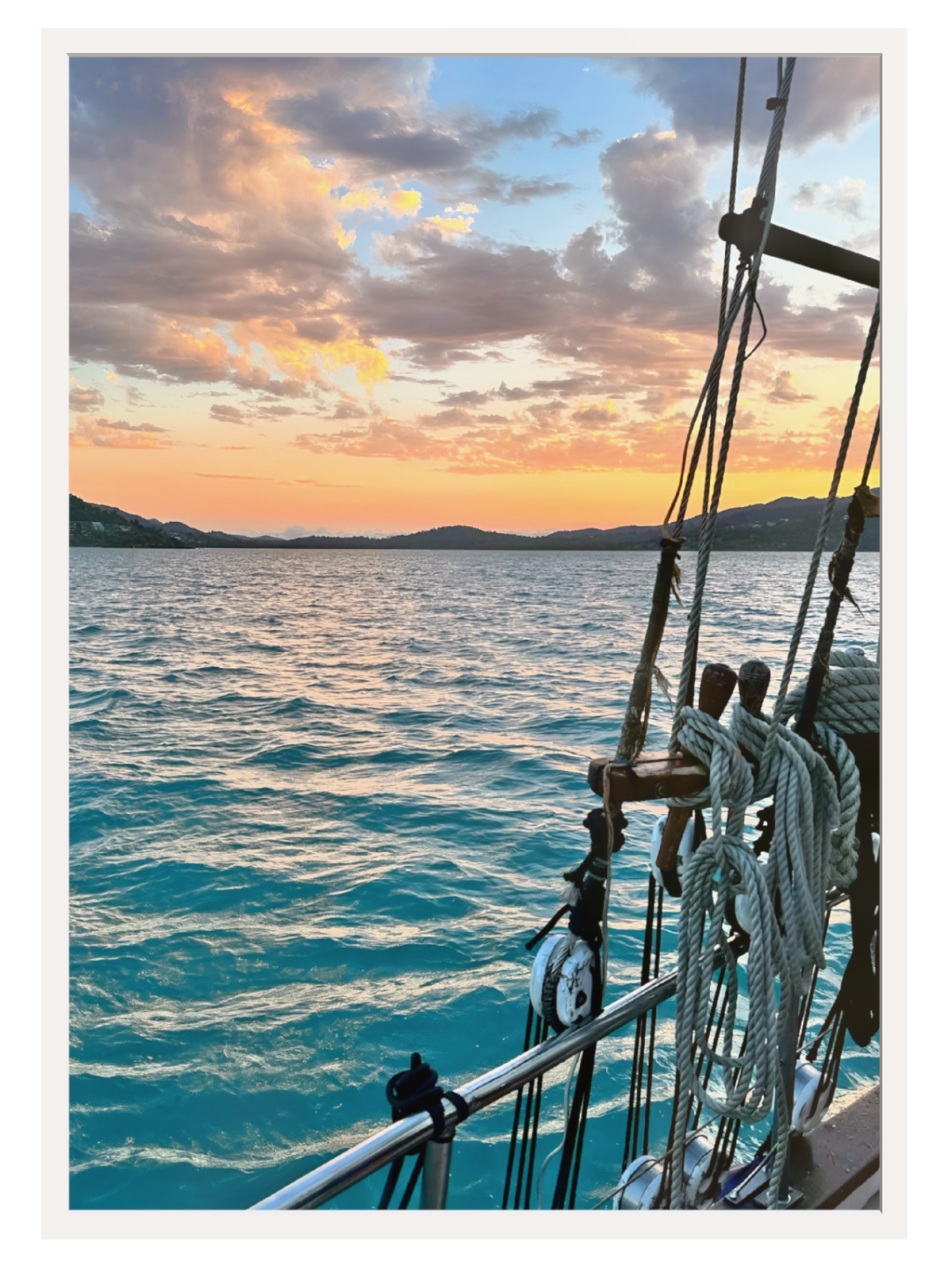 Sailing ship on the ocean with a sunset sky