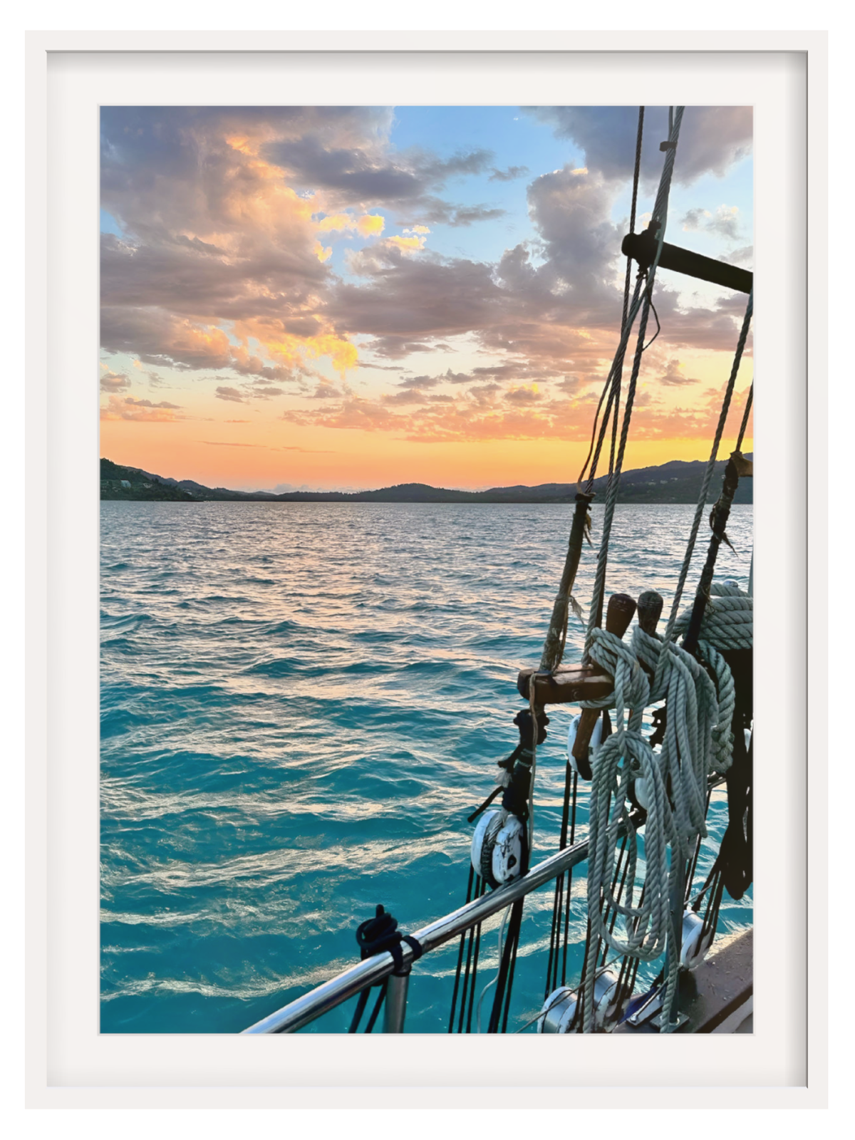 Sailing ship on the ocean with a sunset sky