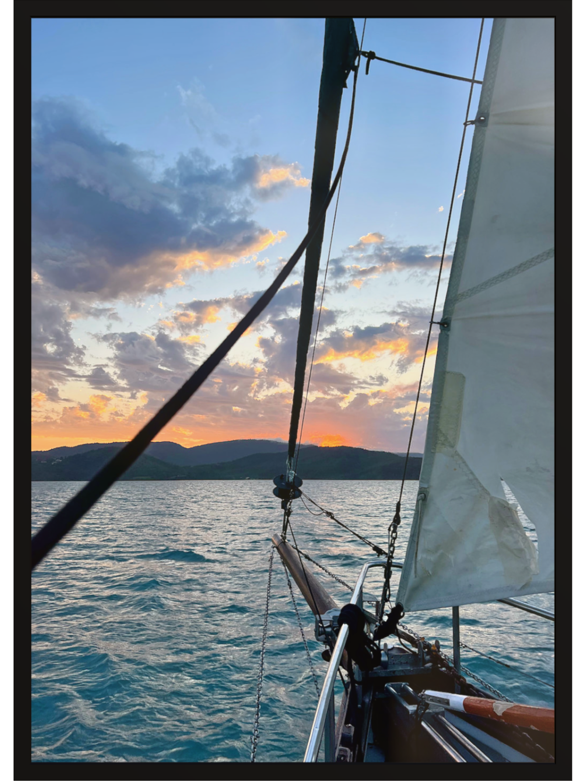 Sailboat on the water with a sunset sky