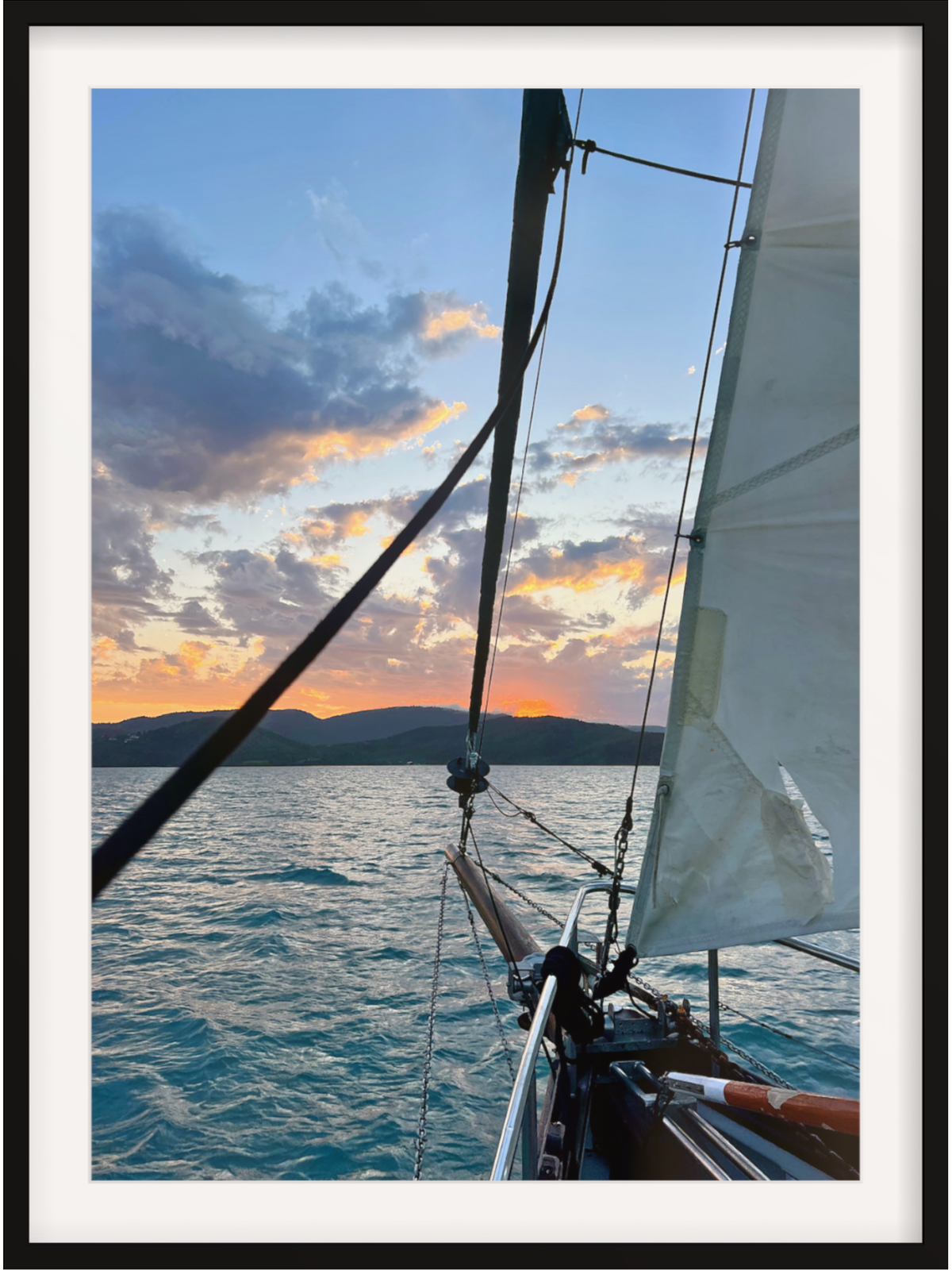 Sailboat on the water with a sunset sky
