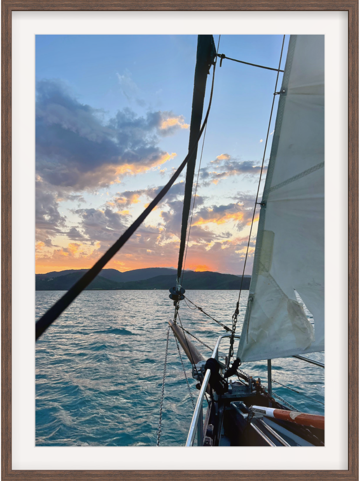 Sailing boat on the water with a sunset in the background