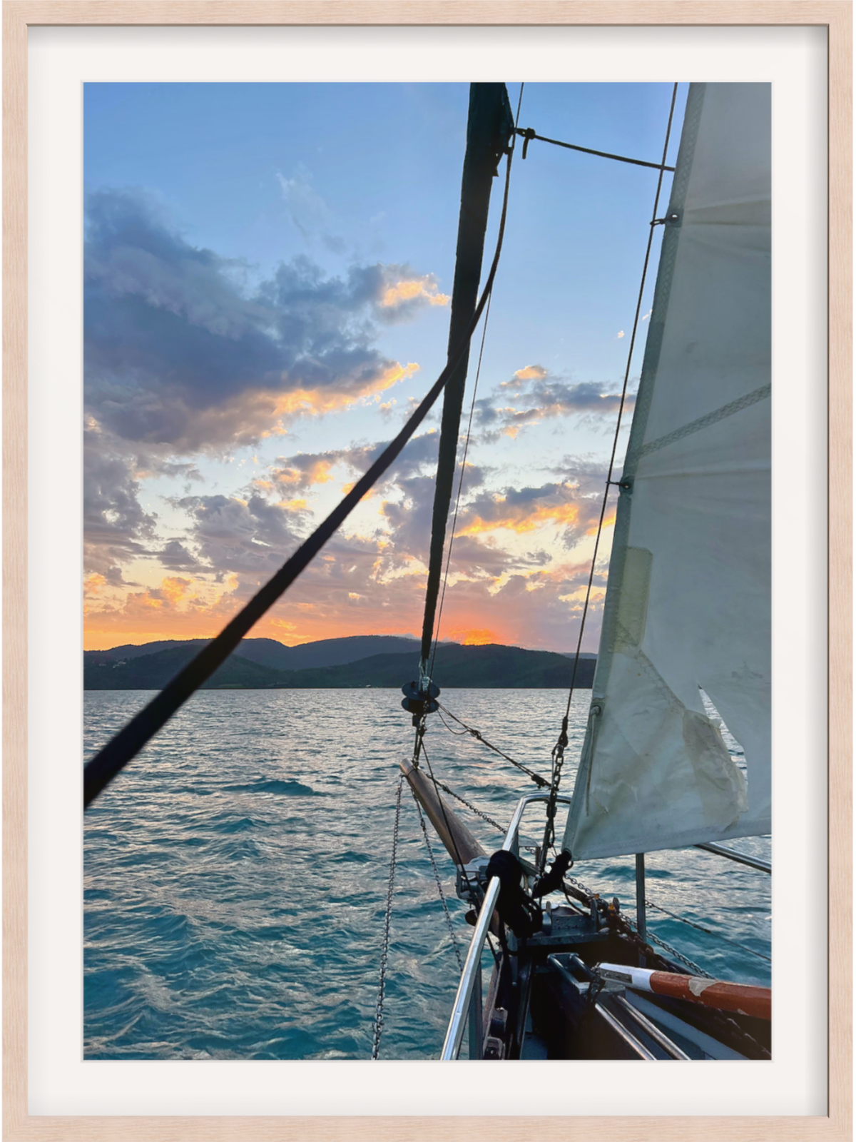Sailing boat on the water with a sunset in the background