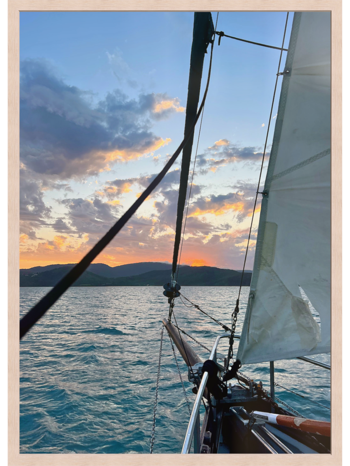 Sailboat on the water with a sunset sky
