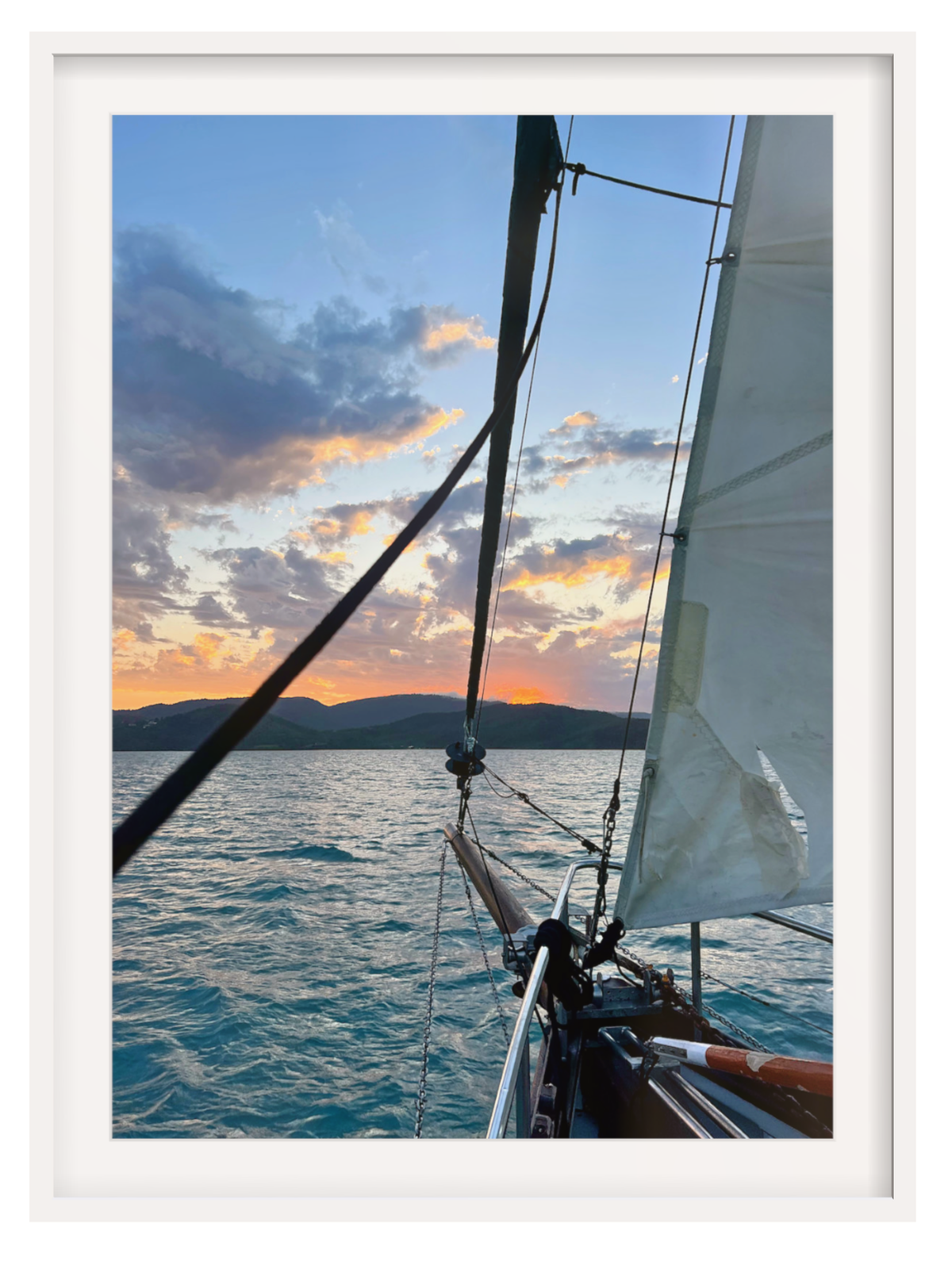 Sailboat on the water with a sunset sky