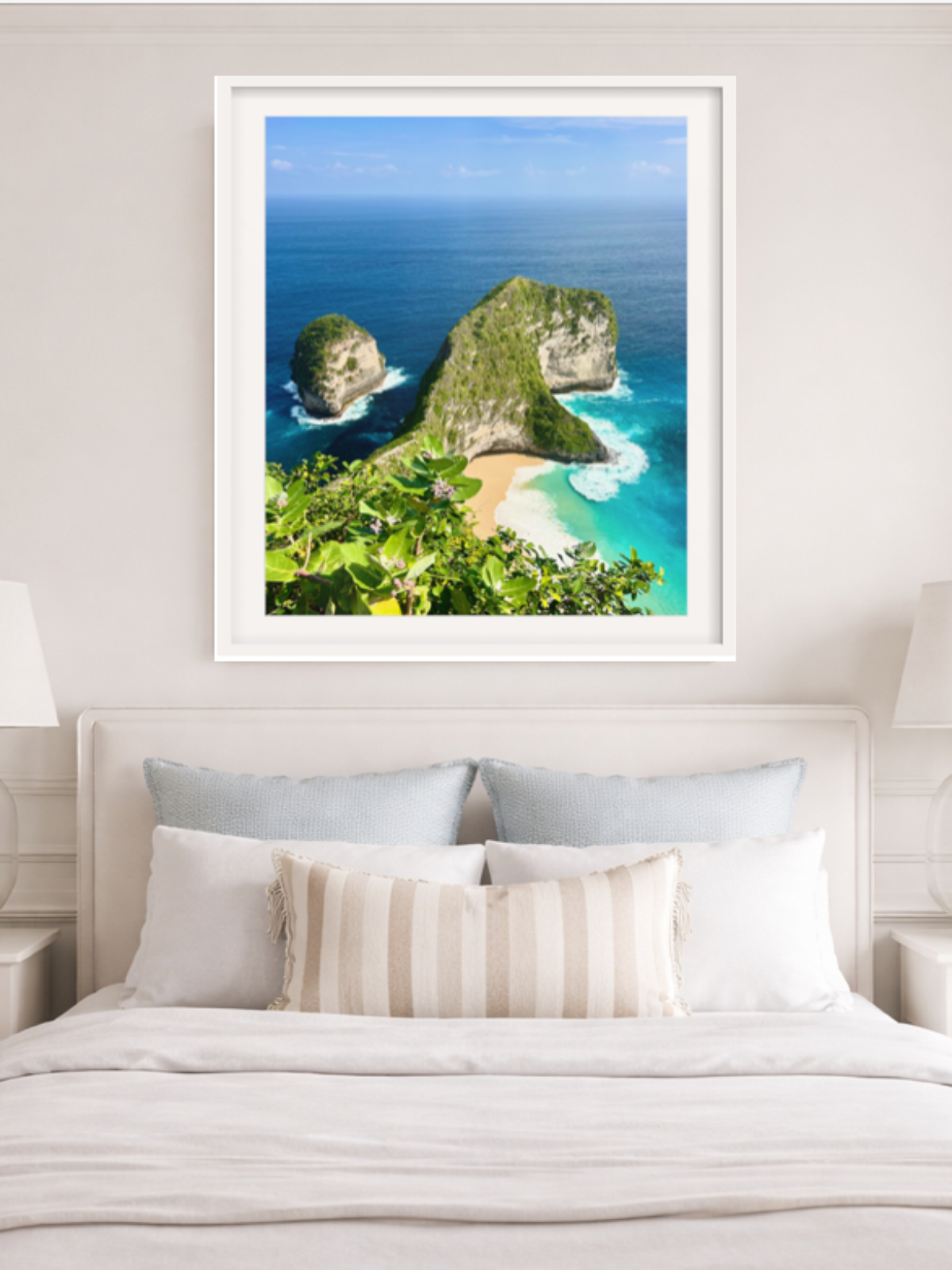Framed tropical landscape print above a bed in a bedroom
