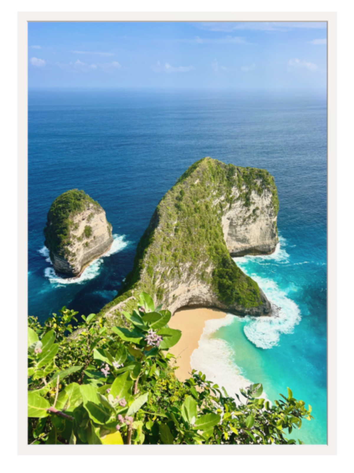 Two rocky islands with a sandy cove surrounded by clear blue water.