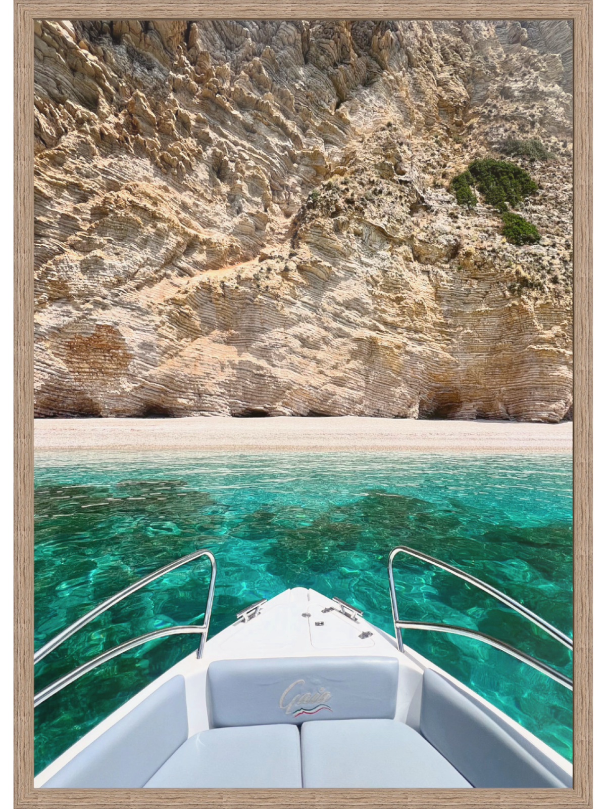 Boat on clear blue water with rocky cliff in the background