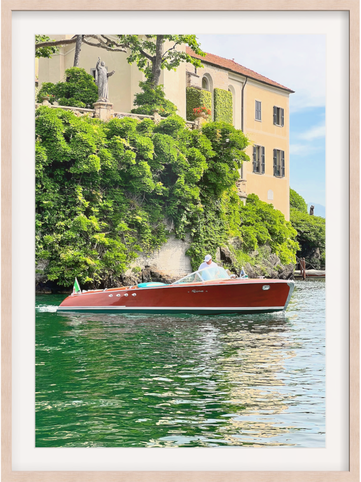 Boat on a body of water with a scenic background featuring trees and buildings.