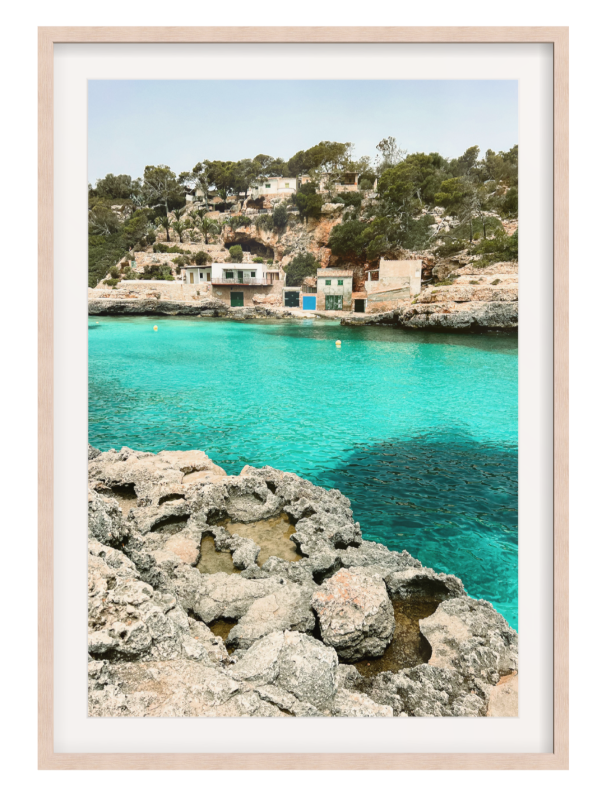 light oak with bordered Framed photograph of a coastal scene with clear blue water and rocky shore.