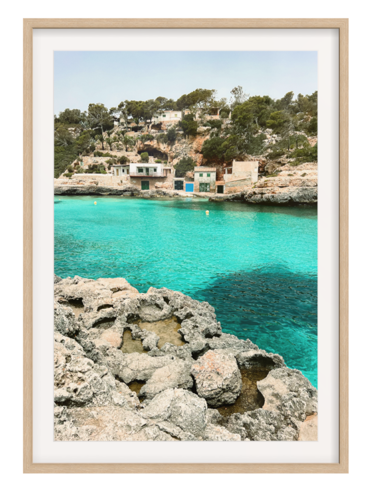 oak Framed photograph of a coastal scene with clear blue water and rocky foreground.