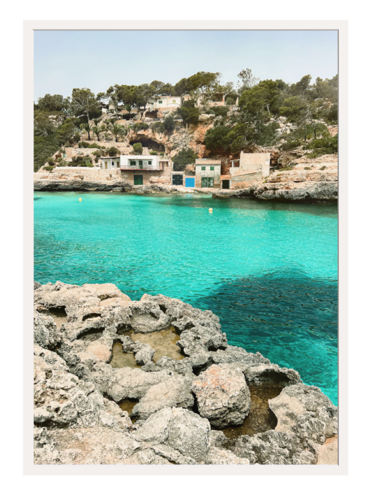 Coastal scene with turquoise water and rocky foreground white frame
