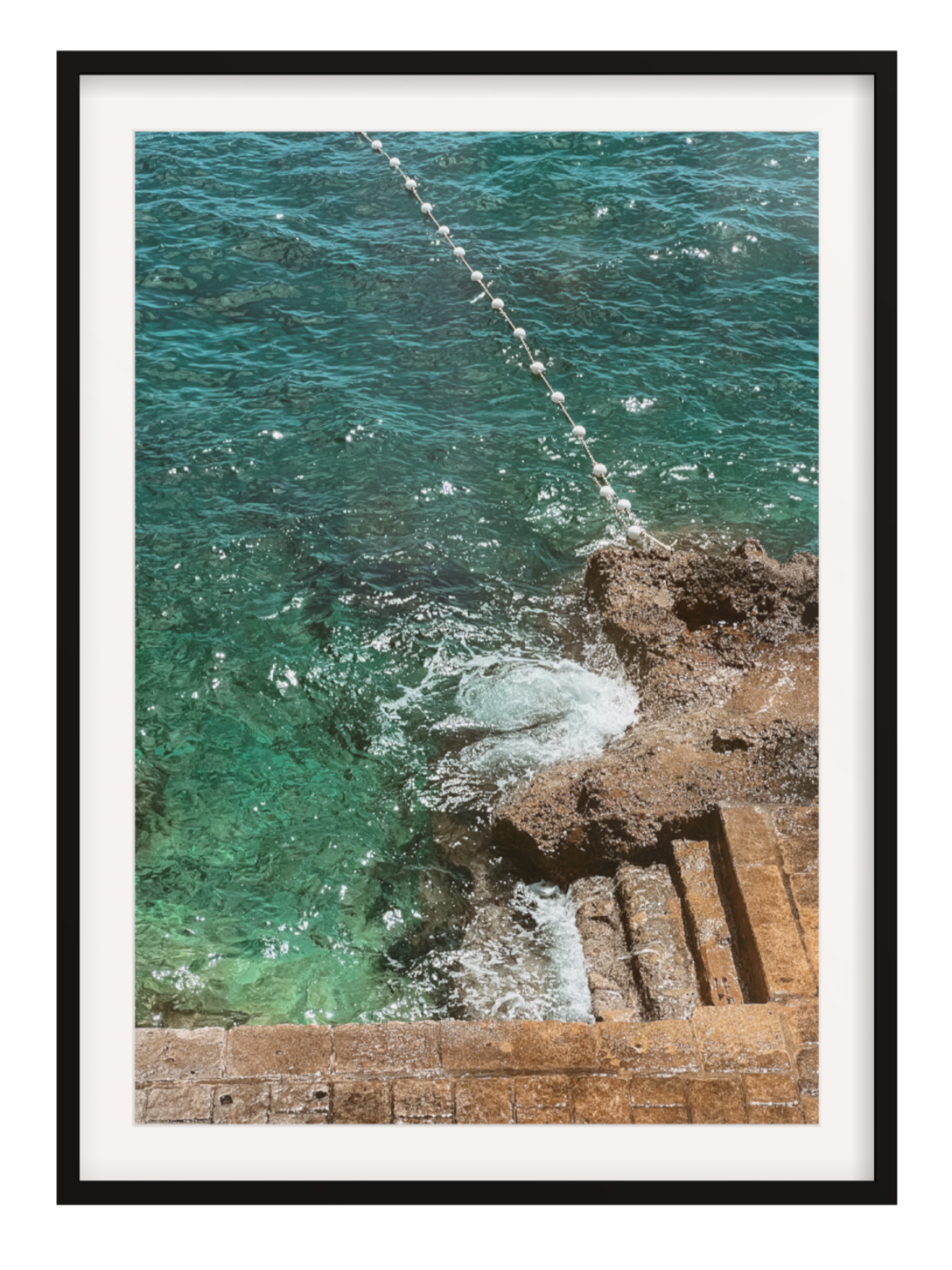 black with border Framed photograph of ocean waves crashing against a rocky shore.