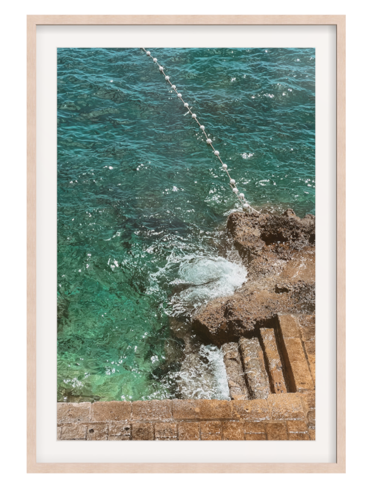 Framed photograph of ocean waves crashing against rocks light oak frame with border