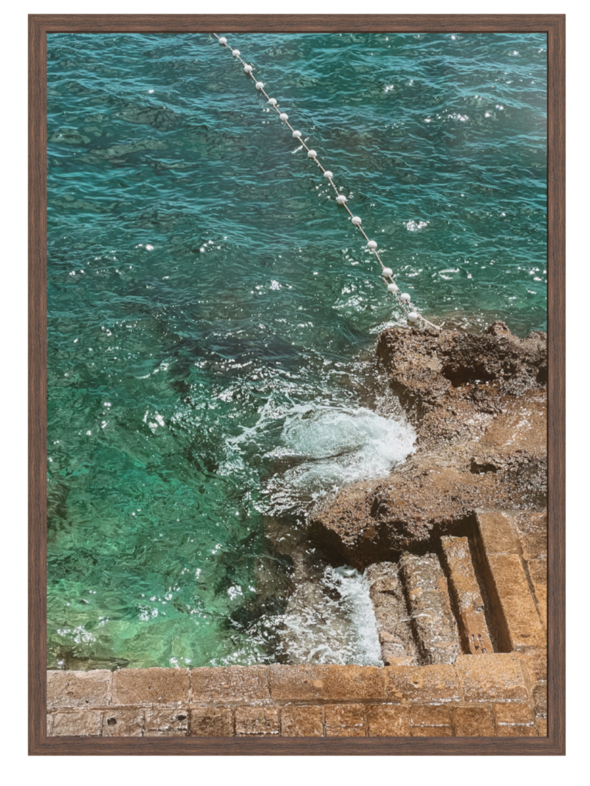 Turquoise ocean water crashing against rocks with a wooden frame. chocolate frame