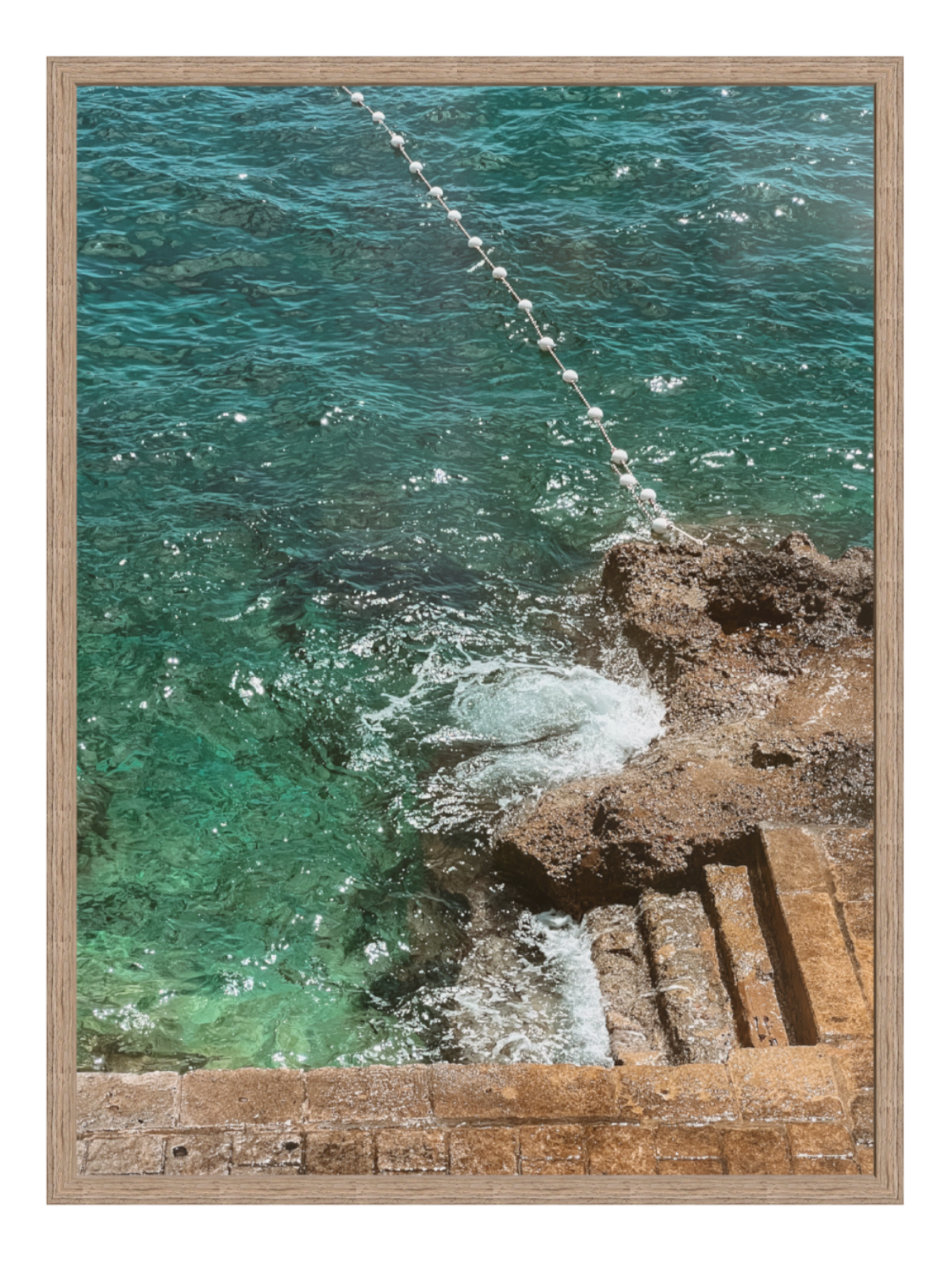 Framed photograph of ocean waves crashing against a rocky shore. hazel frame