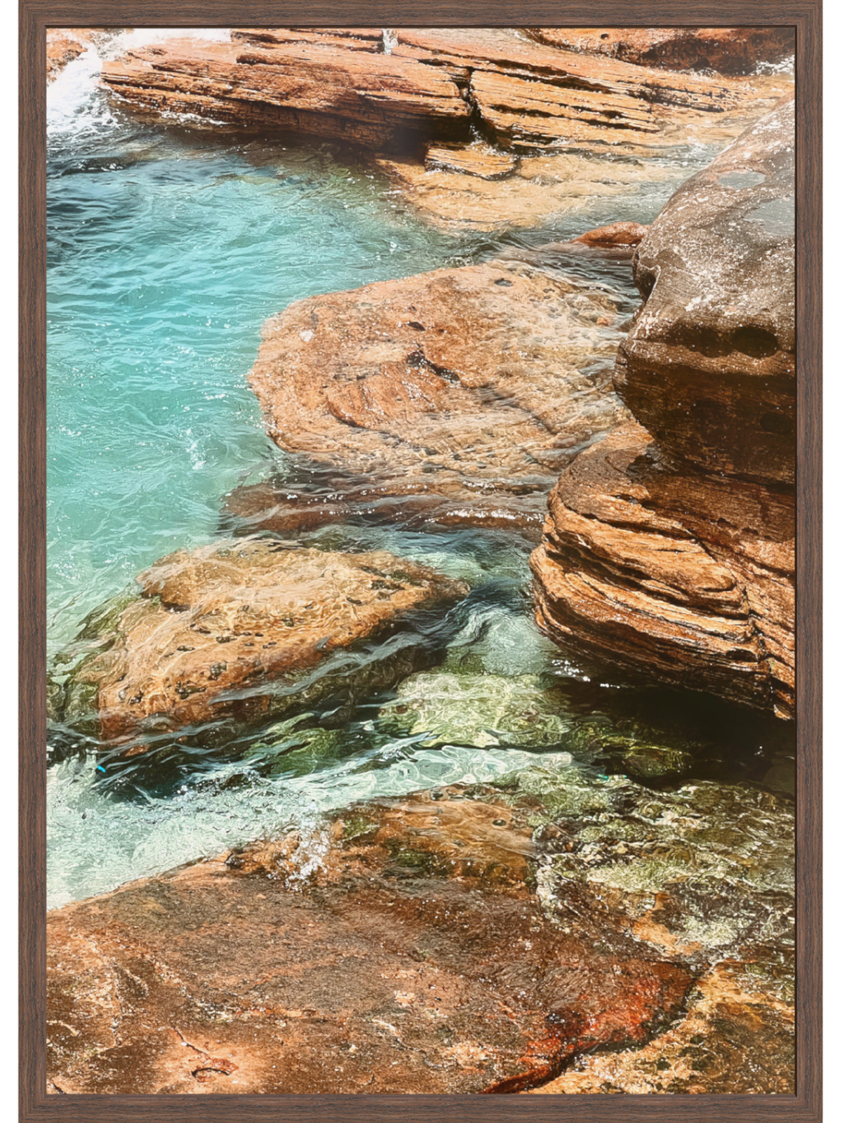 Rocky coastline with clear blue water and a wooden frame.