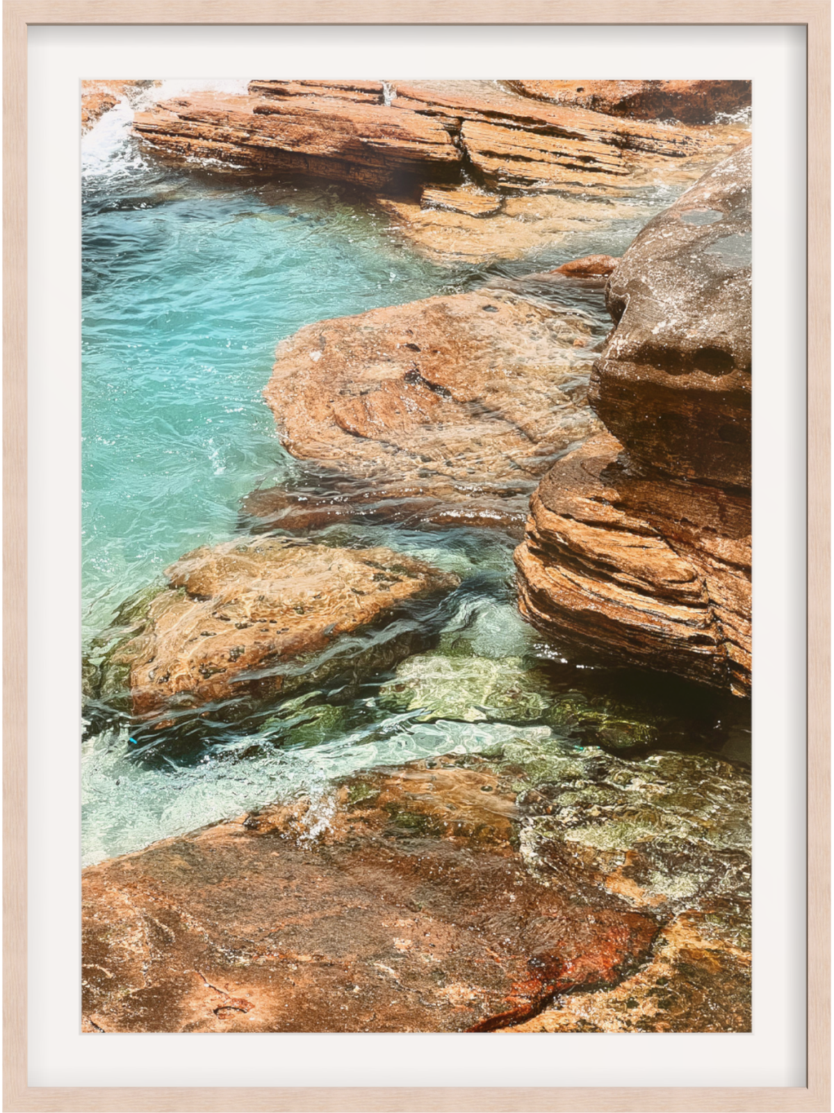 Rocky coastline with clear blue water and a wooden frame.