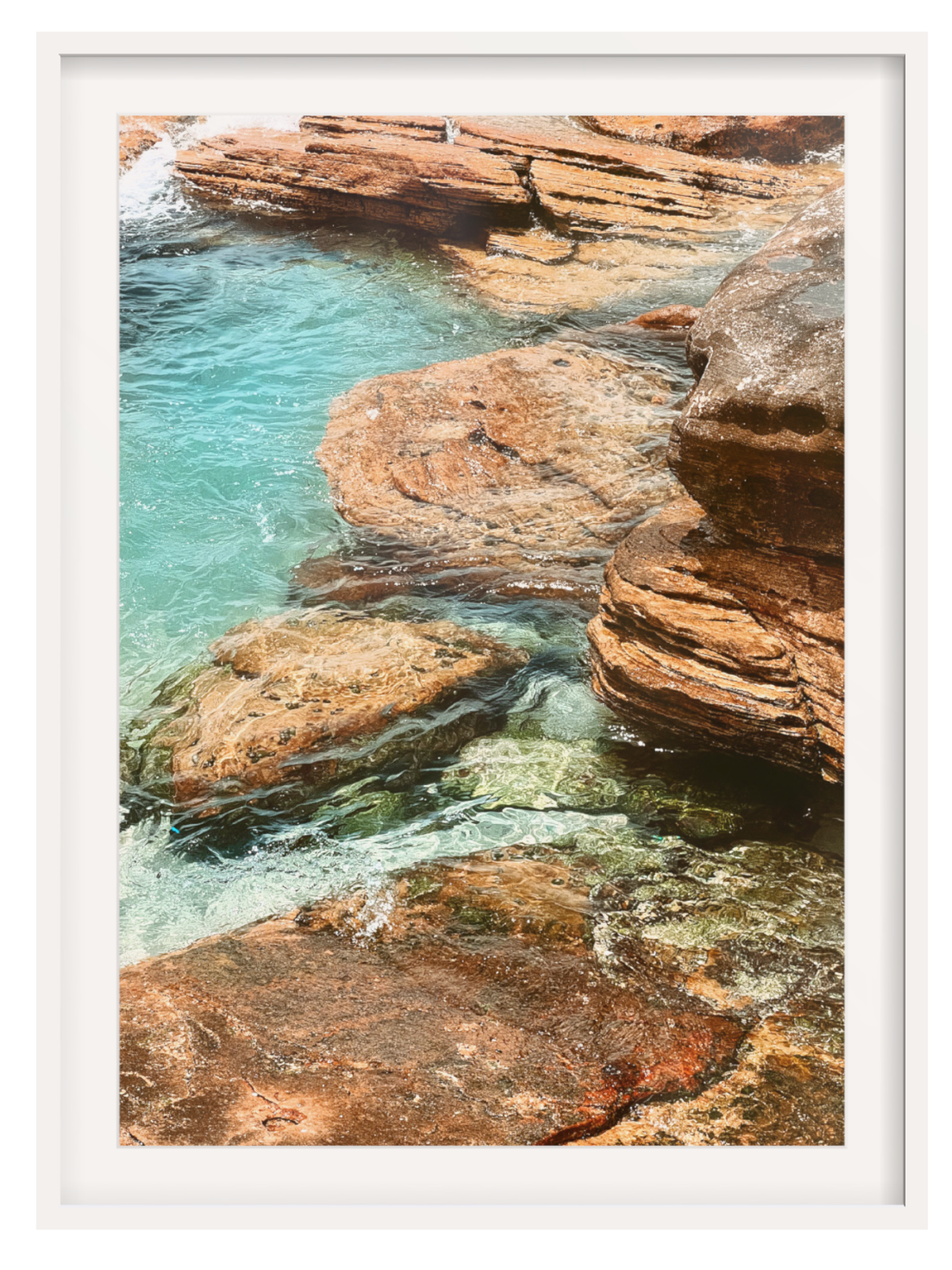 Rocky coastline with turquoise water and a white frame